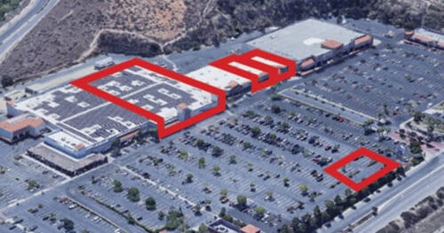 Aerial view of a shopping center with several red outlines highlighting sections of buildings and areas in the parking lot.
